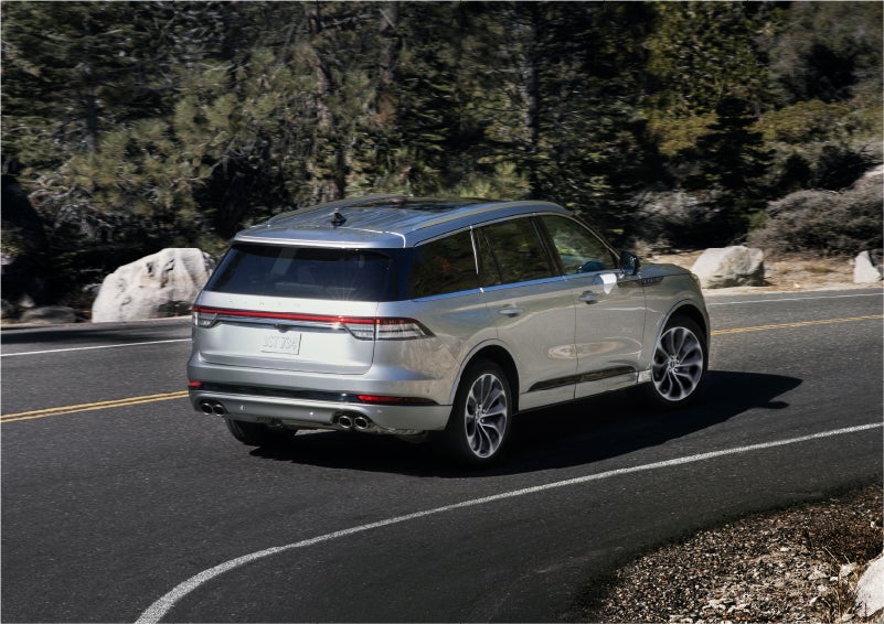 A 2023 Lincoln Aviator® Grand Touring model is shown being driven on a tight turn of a mountain road | Jenkins & Wynne Lincoln in Clarksville TN