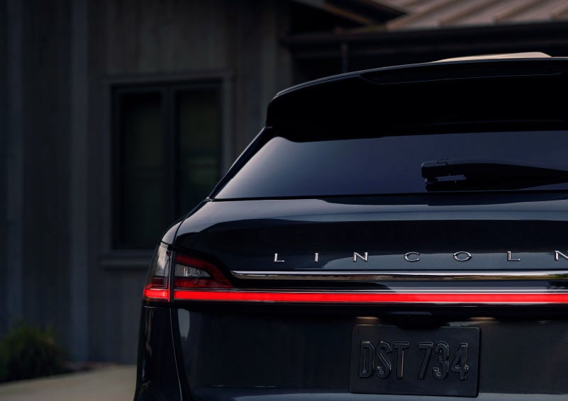 The rear of a 2023 Lincoln Nautilus® SUV is shown with rear taillamps illuminated.