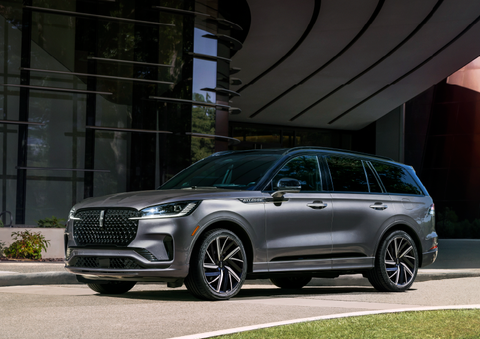 A gray 2025 Lincoln Aviator® SUV is parked outside a modern building showcasing the driver’s side of the vehicle. | Jenkins & Wynne Lincoln in Clarksville TN