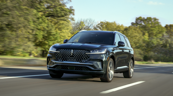 A 2025 Lincoln Black Label Aviator® SUV is being driven down a road lined with trees. | Jenkins & Wynne Lincoln in Clarksville TN