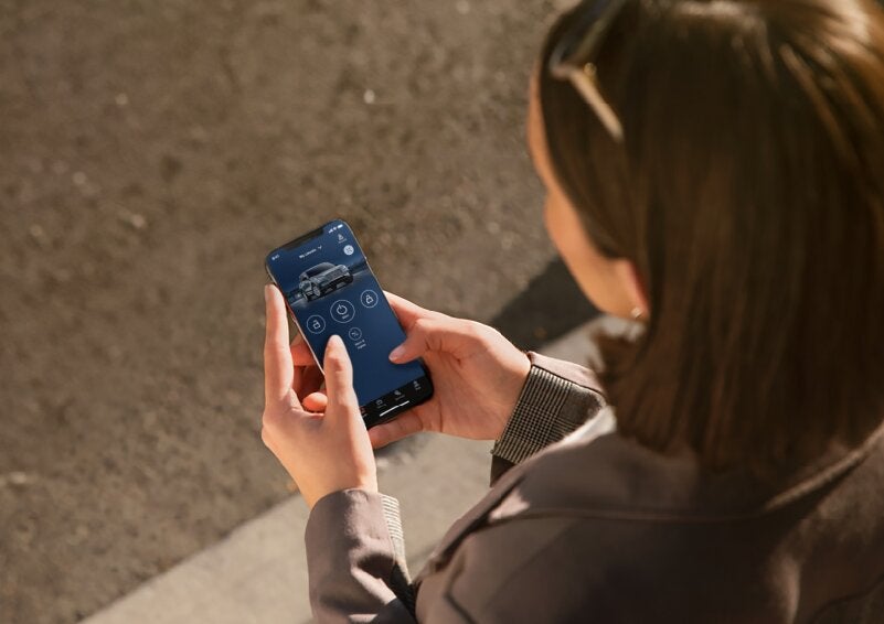 A person is shown interacting with a smartphone to connect to a Lincoln vehicle via the Lincoln Way® App. | Jenkins & Wynne Lincoln in Clarksville TN