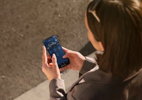 A person is shown interacting with a smartphone to connect to a Lincoln vehicle via the Lincoln Way® App. | Jenkins & Wynne Lincoln in Clarksville TN