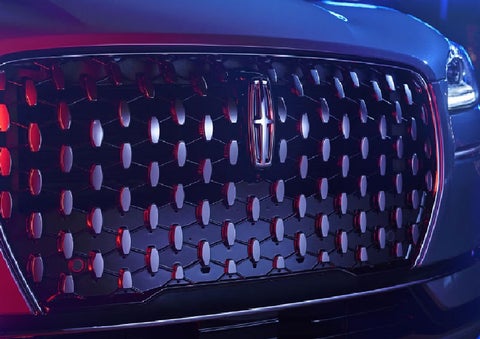 The grille of a 2025 Lincoln Corsair® SUV reflects neon light at night. | Jenkins & Wynne Lincoln in Clarksville TN