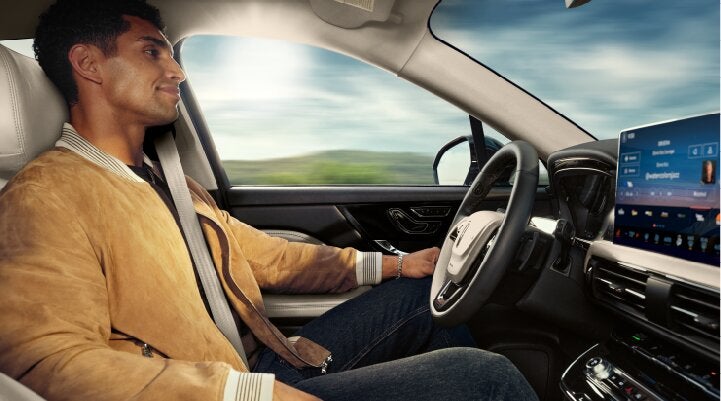 A person is shown using Lincoln BlueCruise hands-free highway driving technology on a divided highway called a Hands-Free Blue Zone. | Jenkins & Wynne Lincoln in Clarksville TN