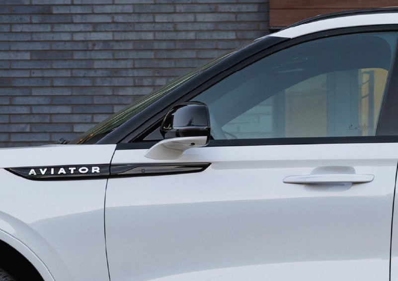 The driver’s side door and fender badging of a white 2026 Lincoln Aviator® SUV are showcased. | Jenkins & Wynne Lincoln in Clarksville TN