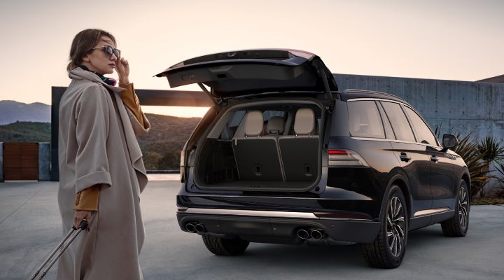 A woman approaches a 2026 Lincoln Aviator® SUV with its rear liftgate open. | Jenkins & Wynne Lincoln in Clarksville TN